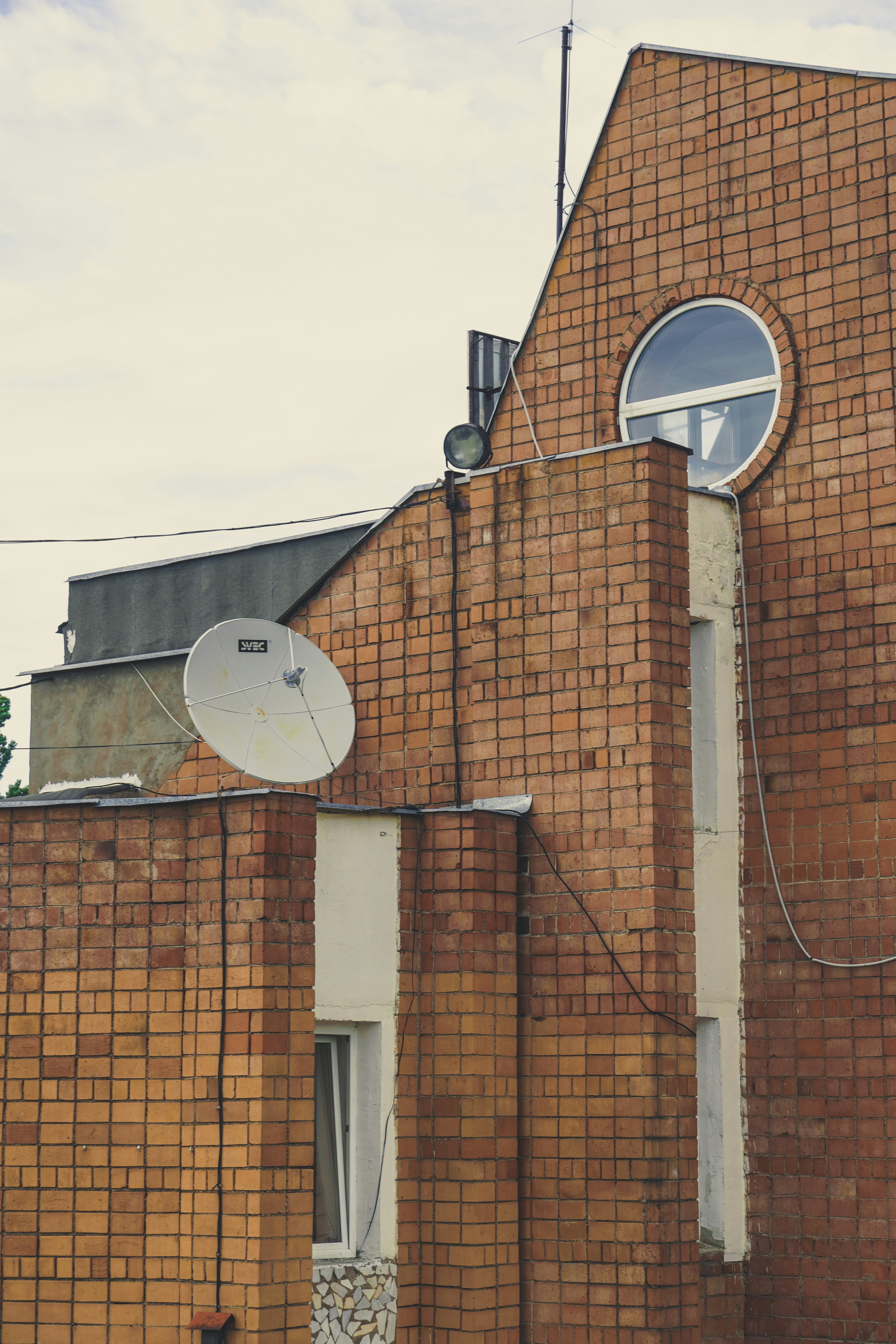 brown brick building with white satellite dish
